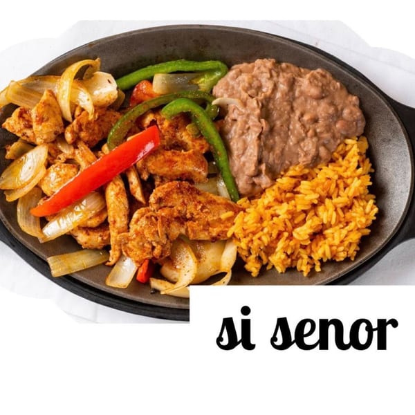 Si Senor Mexican Restaurant's chicken fajitas with onions, peppers, rice, and refried beans on a sizzling platter.