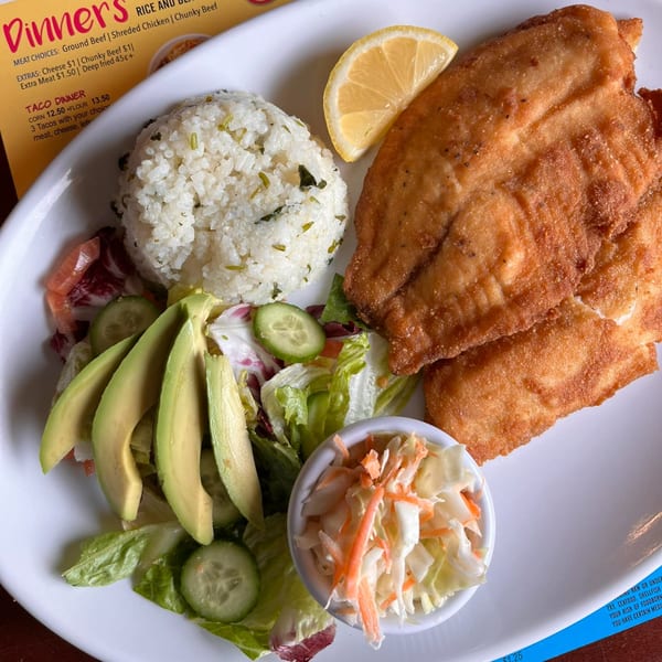 Si Senor Mexican Restaurant's fried fish dinner with rice, salad, avocado, coleslaw, and a lemon wedge.